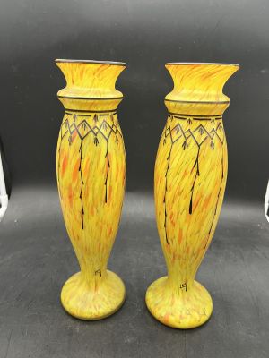 une paire de vases jaunes posés sur une table noire