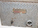 an old metal box with holes and a sign on it
