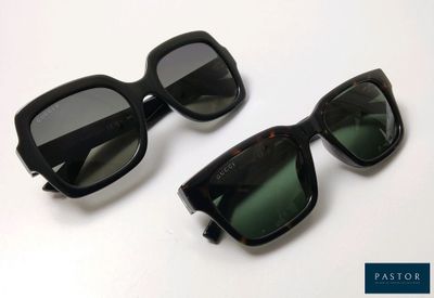 pair of black sunglasses with green lenses on a white surface