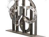 a metal sculpture of a machine that is sitting on a stand