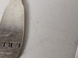 a silver spoon with the word frt on it sitting on a table