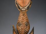 une photo d'une sculpture en bois représentant un poisson, posée sur un socle