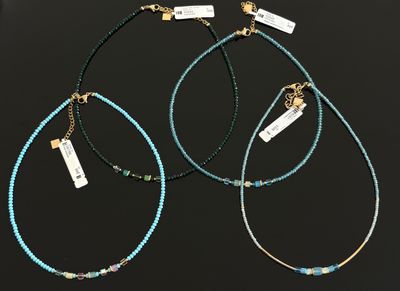 trois colliers composés de perles de turquoise et d'or sur fond noir