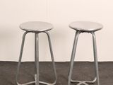 two metal stools sitting next to each other in a room