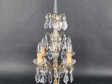 an image of a gold and crystal chandelier with three candles