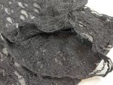 a close up of a black lace shirt on a white surface