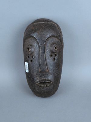 une image représentant un masque en bois sur fond gris