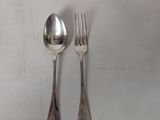 two spoons and a fork on a white table