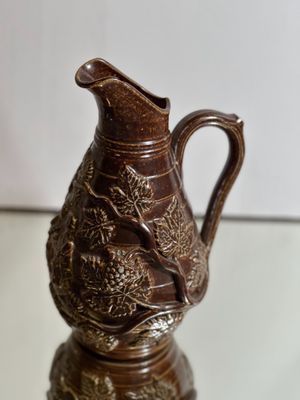 un pichet marron posé sur une table en verre