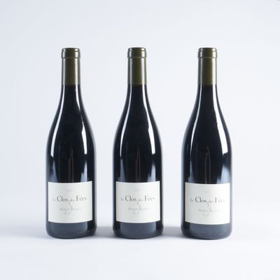 trois bouteilles de vin sont alignées sur une surface blanche
