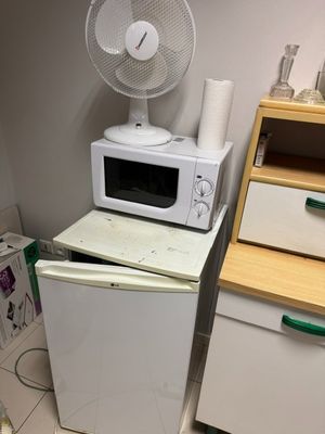 un micro-ondes blanc posé sur un réfrigérateur blanc