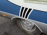 a blue and white rv parked in a parking lot