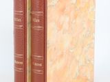 two red books sitting on top of each other on a white surface