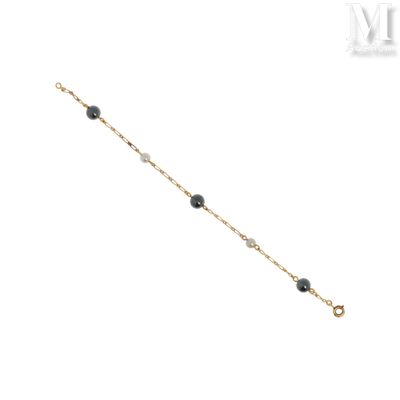 un gros plan d'un bracelet composé de perles noires sur fond blanc