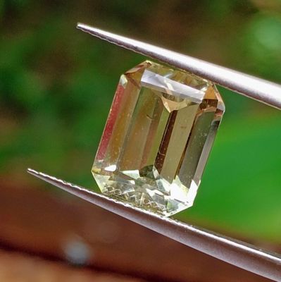 a yellow diamond that is being held by a pair of tongs
