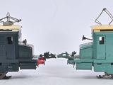 deux petits trains assis côte à côte sur une surface blanche