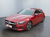une Mercedes CLA rouge garée dans une pièce blanche