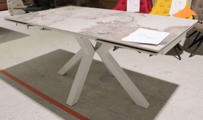 une table blanche avec un plateau en marbre, sur laquelle se trouve un livre
