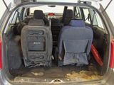 two seats in the back of a car with luggage in the trunk