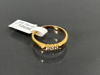 gros plan d'une bague en or avec des diamants sur une surface noire