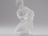 an image of a glass sculpture of a man kneeling on a base