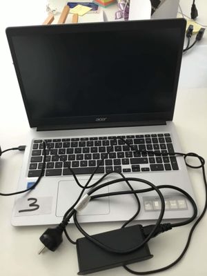 a laptop that is sitting on a desk with a charger on it