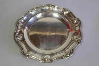 un plateau en argent posé sur une table blanche, orné d'un ruban rouge