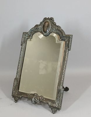 une photo d'un miroir argenté posé sur une table blanche