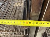 a measuring tape on the floor next to a pile of metal pipes