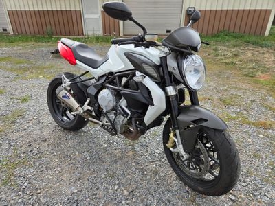 une moto blanche et noire garée devant un immeuble
