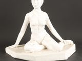statue d'une femme assise en position du lotus sur un socle en marbre