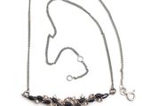 gros plan d'un collier sur une surface blanche avec une chaîne