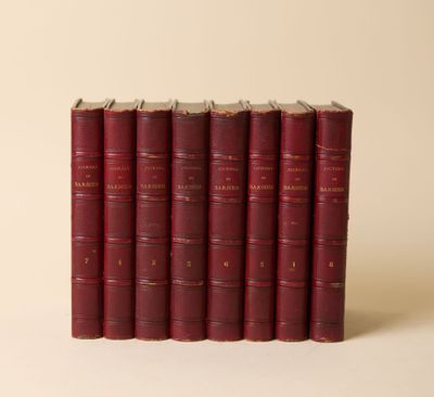 six livres rouges empilés les uns sur les autres sur une surface blanche