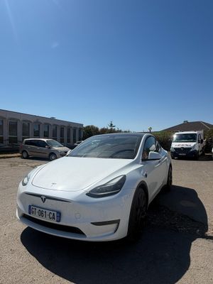 une Tesla blanche garée sur un parking