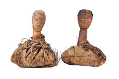 paire de sculptures en bois représentant des têtes, posées sur un morceau de bois