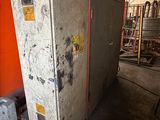 an old refrigerator sitting in a warehouse with a red wall