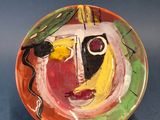 une assiette colorée ornée d'une peinture sur un fond bleu