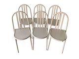 six white metal chairs sitting next to each other on a white surface