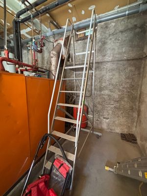 a picture of a room with a ladder and a bag on the floor