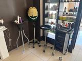 une photo d'un salon de coiffure avec un sèche-cheveux et un fauteuil
