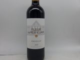 la bouteille de vin rouge est posée sur une surface blanche
