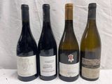 four bottles of wine are lined up on a table