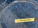 a blue vase with a label on it sitting on a table