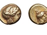 a close up of two gold coins with a bird on them