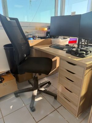 a desk with two computer monitors and a chair in front of it