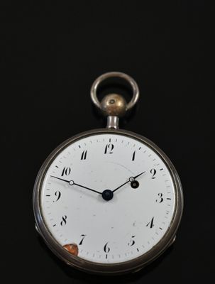a close up of a pocket watch on a black surface