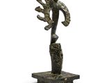 an image of a bronze sculpture of a person on a rock