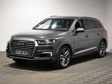 L'Audi QX est garée dans un garage dont le sol est recouvert d'un motif à damier.