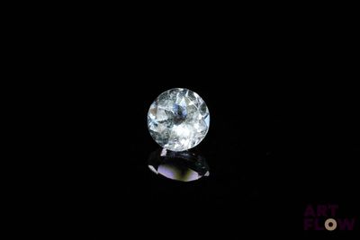 a close up of a white diamond on a black surface