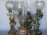 a lot of antique lamps that are sitting on a table